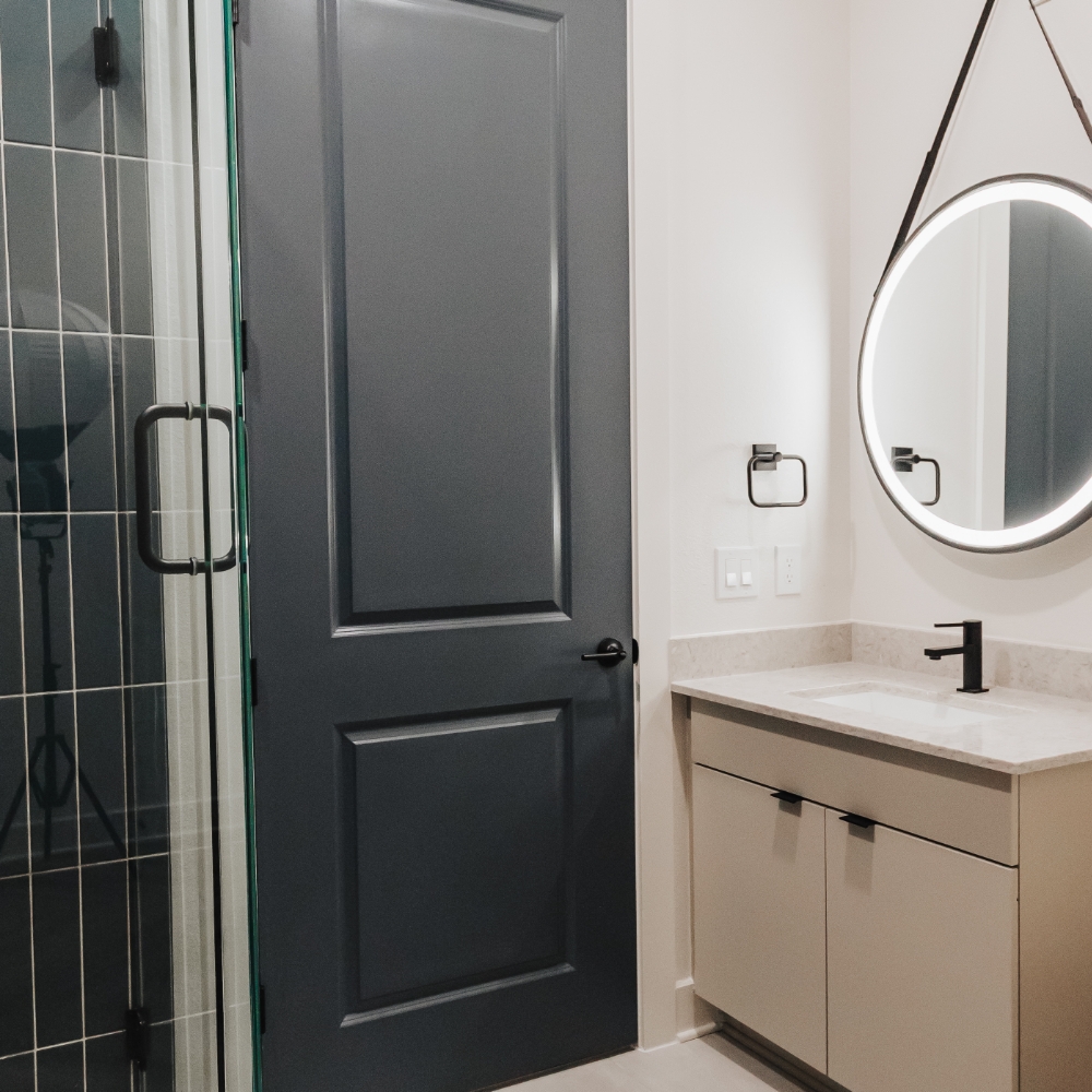 Bathroom with vanity and round mirror